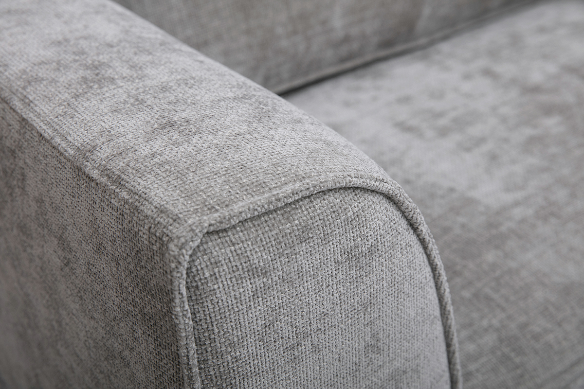 D�tail d'un accoudoir de canap� en tissu effet velours textur� gris.