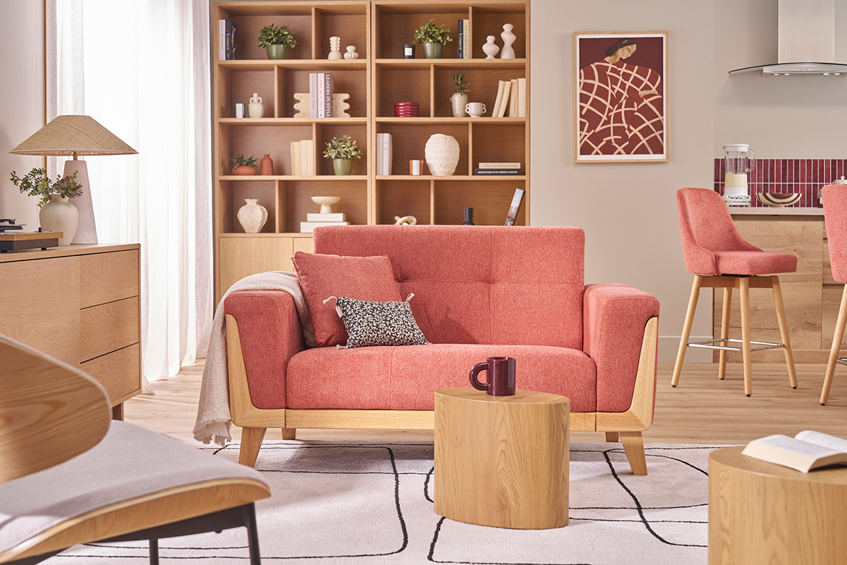 Canap� scandinave terracotta � deux places avec bois clair dans un salon moderne.
