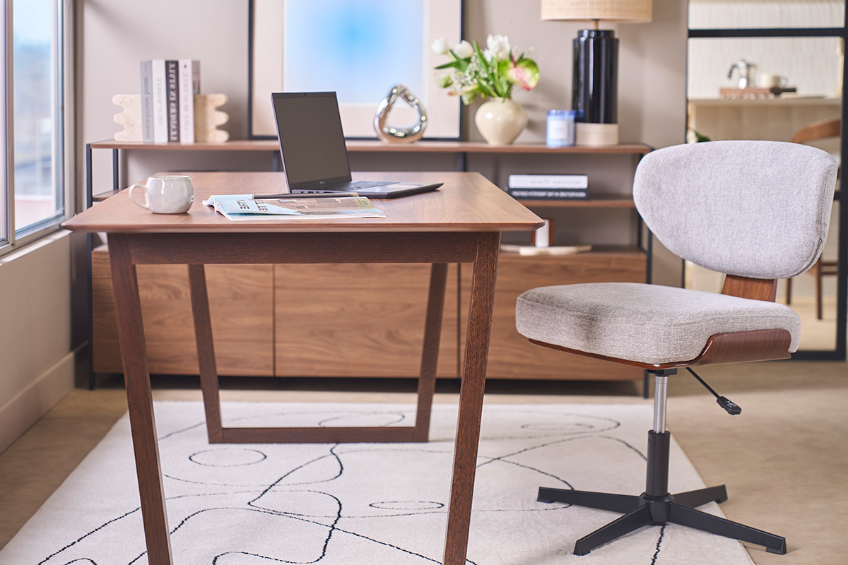 Chaise de bureau en tissu gris et bois noyer, vue de c�t� pr�s d'un bureau moderne.