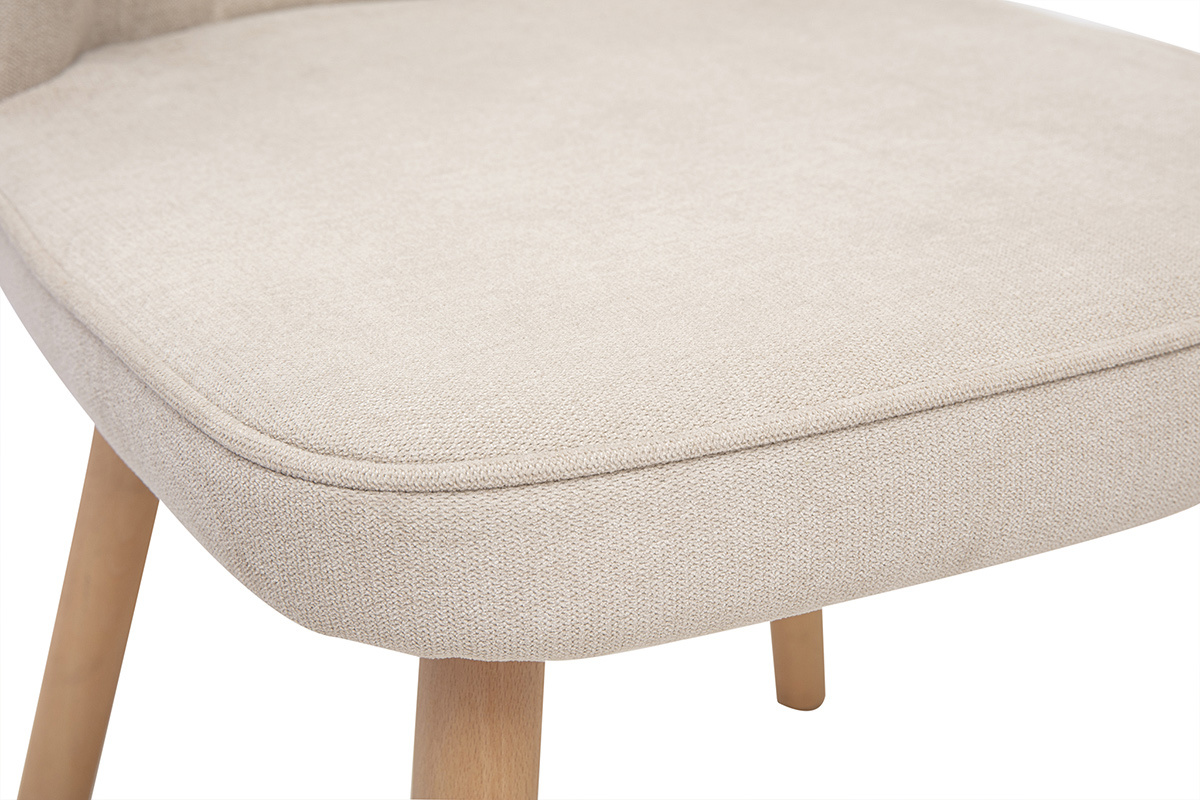 Gros plan sur l'assise d'une chaise en tissu effet velours beige avec pieds en bois clair.