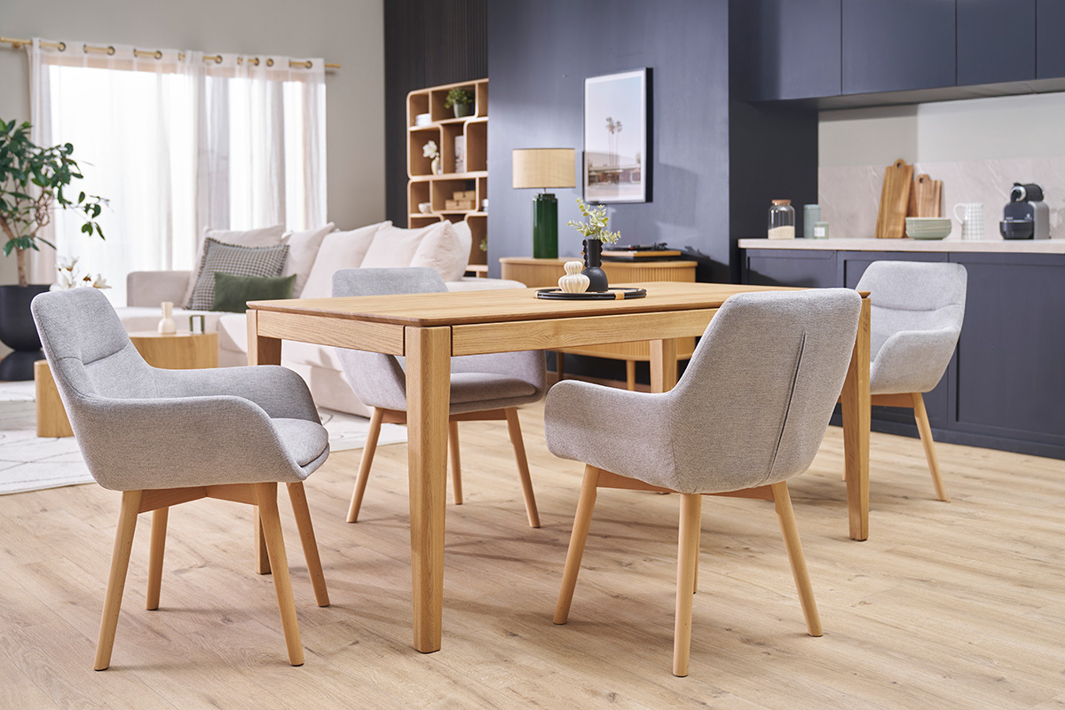Chaises ALESS en tissu gris et bois clair autour d'une table en bois dans un salon.