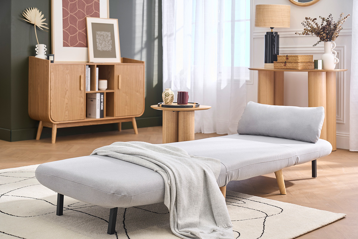 Fauteuil convertible AMIKO gris clair au style scandinave, pr�sent� en position lit dans un int�rieur moderne.