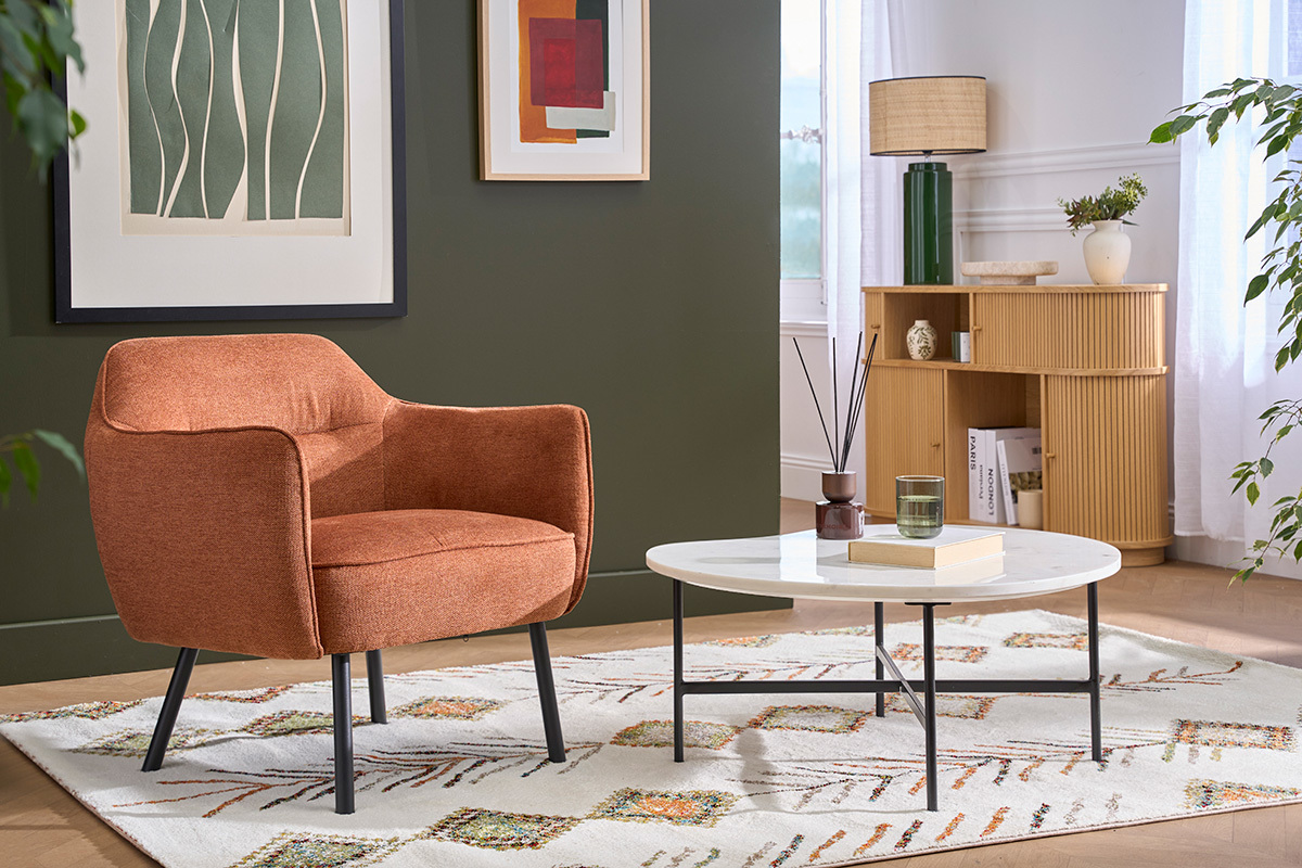 Fauteuil LAURENS en tissu terre br�l�e, vue de 3/4, dans un int�rieur moderne avec table basse.