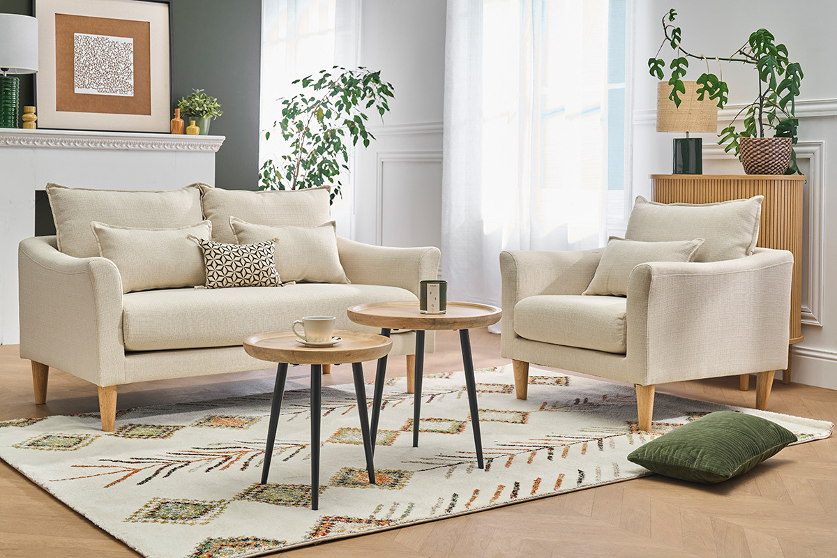 Fauteuil scandinave beige KATE avec coussins, entour� de tables basses, vue d'ensemble dans un salon
