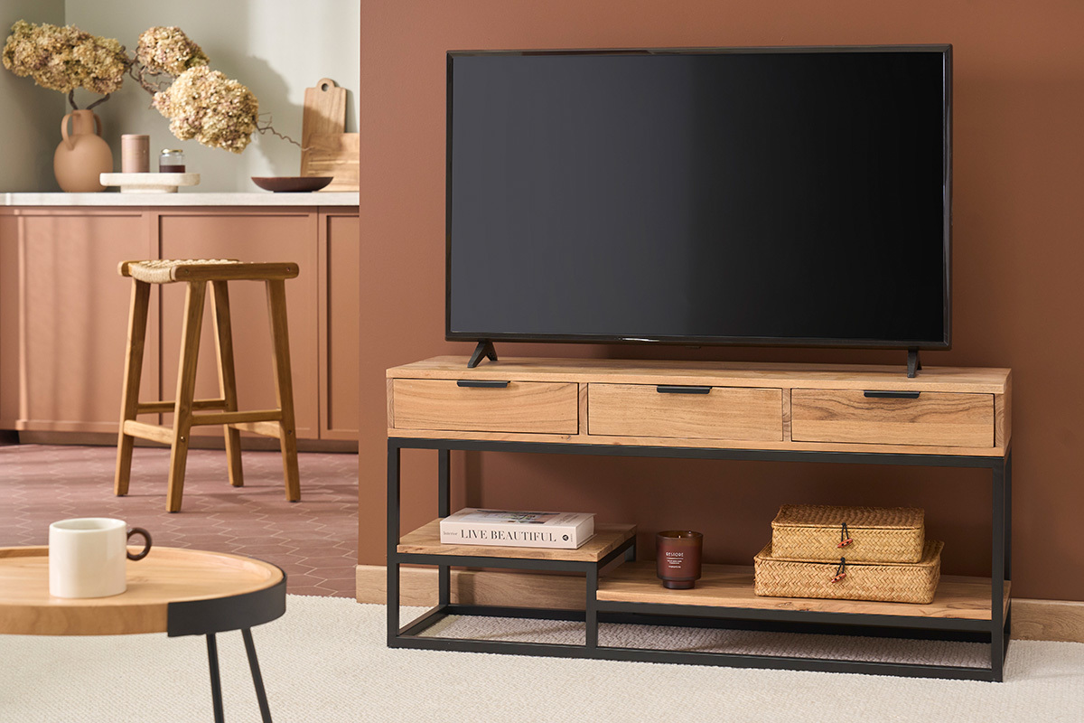 Meuble TV en bois acacia et m�tal noir avec trois tiroirs et �tag�res, �cran dessus.