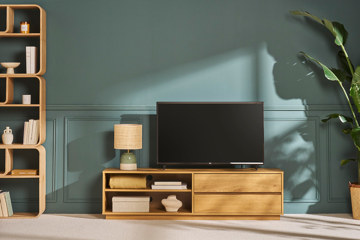 Meuble TV bois 2 tiroirs et niches, avec t�l�vision, �tag�re et plante, vue de face.