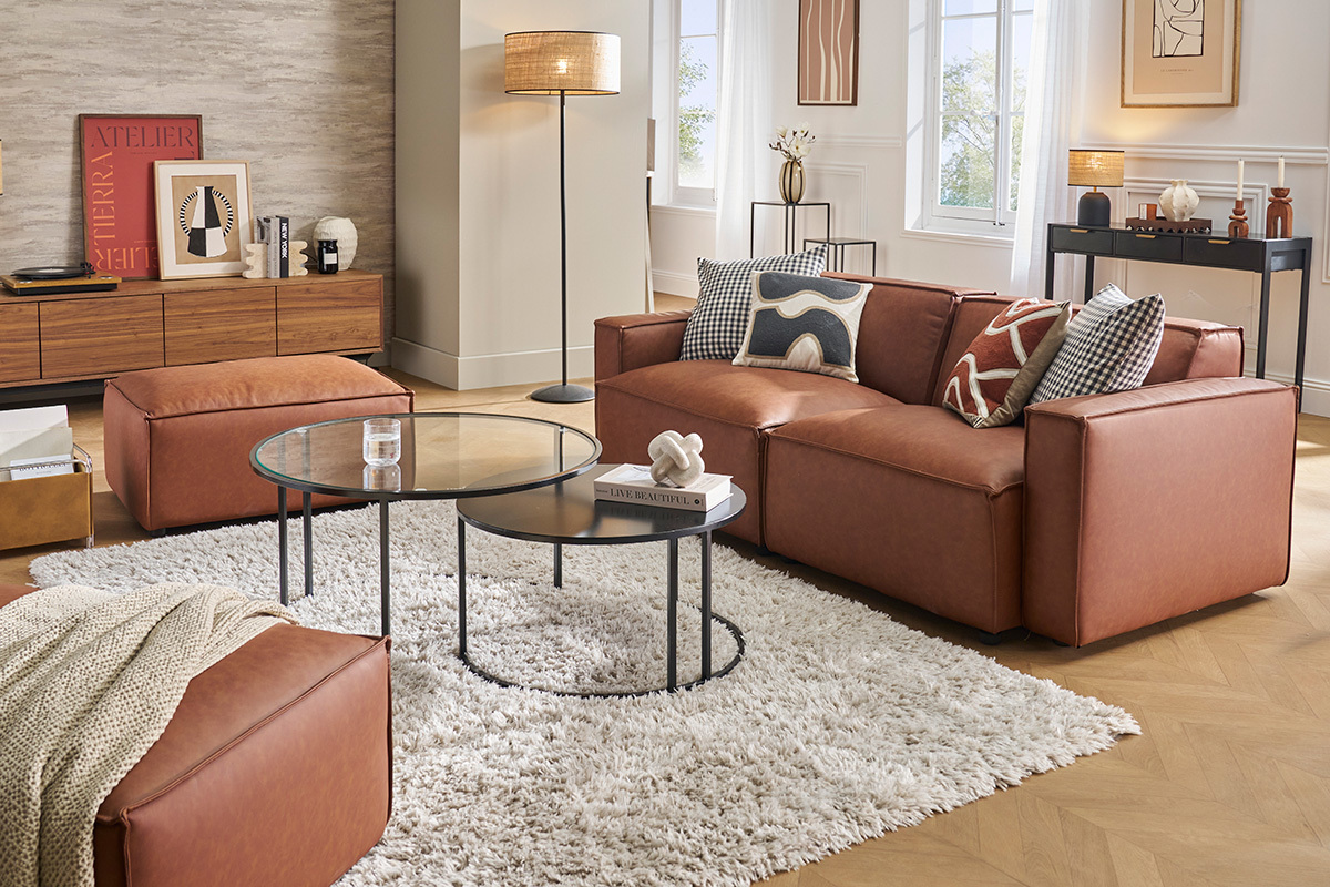 Salon avec pouf en cuir marron SPLIT, canap� assorti, tapis et tables basses rondes.