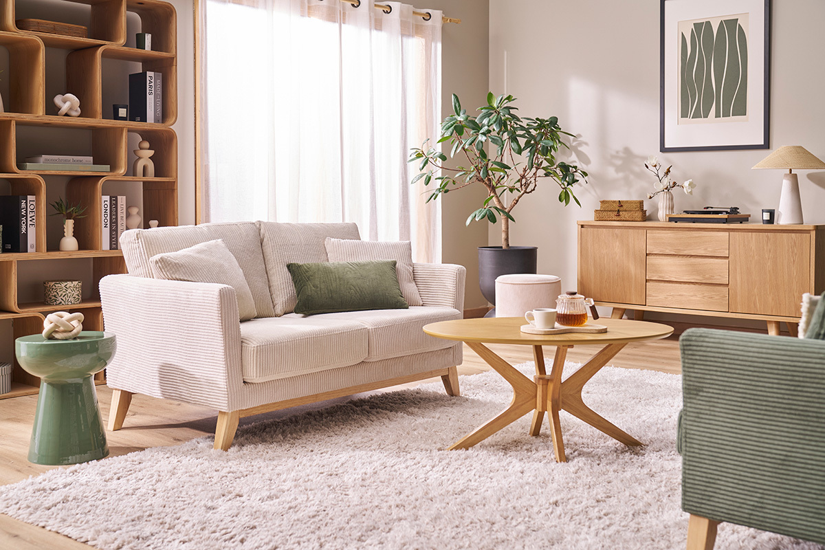 Table d'appoint ronde en m�tal �maill� vert kaki dans un salon avec canap� et table basse.