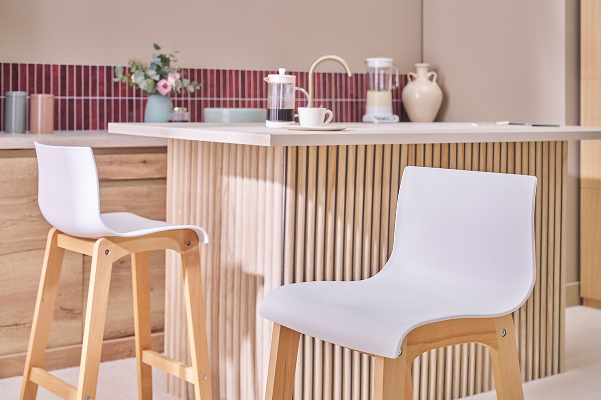 Tabourets de bar design bois et blanc H65 cm devant un �lot central.