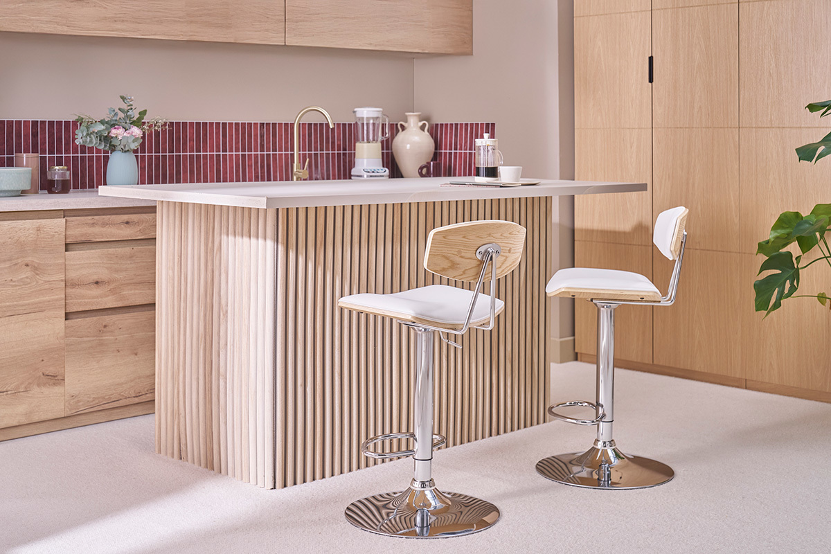 Tabourets de bar r�glables blancs et bois clair devant un comptoir dans une cuisine moderne.