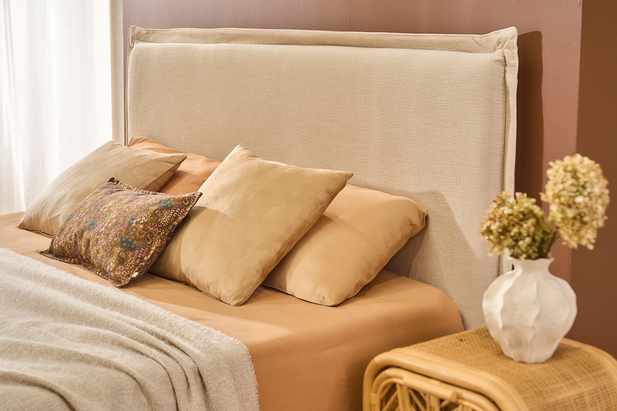 T�te de lit en tissu beige effet lin avec oreillers, vue lat�rale.